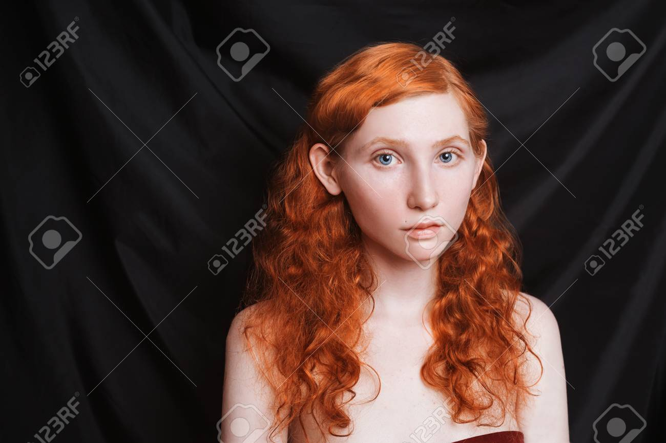 Makeup For Blue Eyes Red Hair Woman With Long Curly Red Flowing Hair On A Black Background